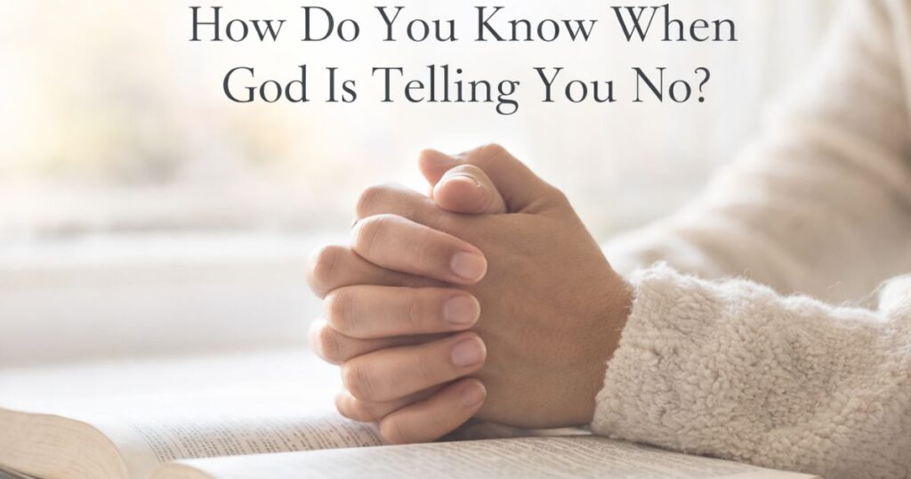 How do you know when God is telling you no shown through prayerful hands resting on an open Bible